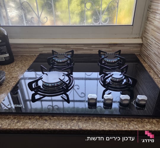 כיריים גז במטבח עם חלון ברקע